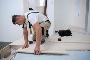 arbeider installeren nieuw gelamineerd houten verdieping foto