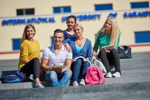 studenten buiten zittend Aan stappen foto