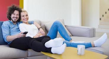 jong koppel op de bank televisie kijken foto