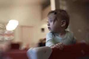 schattig weinig baby spelen in mobiel bed foto