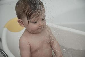 schattig weinig baby meisje nemen een bad foto