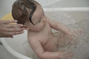 schattig weinig baby meisje nemen een bad foto