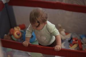 schattig weinig baby spelen in mobiel bed foto