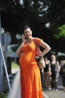 gelukkig zwanger vrouw pratend door mobiele telefoon foto