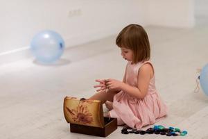 weinig meisje genieten van terwijl spelen met moeder sieraden foto