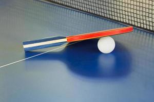 peddelen, tennis bal Aan blauw ping pong tafel foto