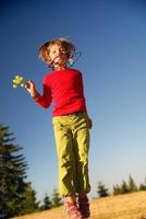 gelukkig kind jumping in natuur foto