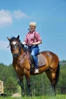 gelukkig vrouw rijden paard foto