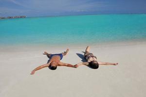 gelukkig jong paar genieten van zomer Aan strand foto