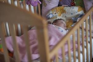 pasgeboren baby slapen Bij huis in bed foto