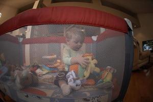 schattig weinig baby spelen in mobiel bed foto