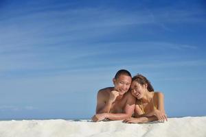 gelukkig jong paar genieten van zomer Aan strand foto