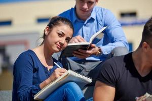 studenten buiten zittend Aan stappen foto