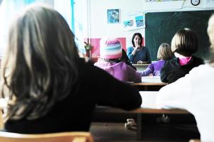 gelukkig kinderen met leraar in school- klas foto