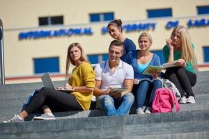 studenten buiten zittend Aan stappen foto