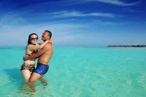 gelukkig jong paar genieten van zomer Aan strand foto