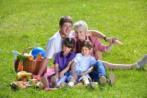 gelukkig familie spelen samen in een picknick buitenshuis foto