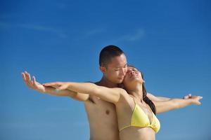 gelukkig jong paar genieten van zomer Aan strand foto