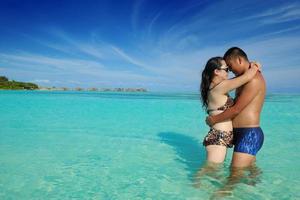 gelukkig jong paar genieten van zomer Aan strand foto