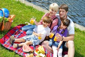 gelukkig familie spelen samen in een picknick buitenshuis foto