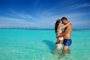 gelukkig jong paar genieten van zomer Aan strand foto