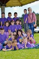 groep gelukkige kinderen met leraar in de natuur foto