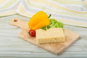 geel kaas Aan houten bord en houten achtergrond foto