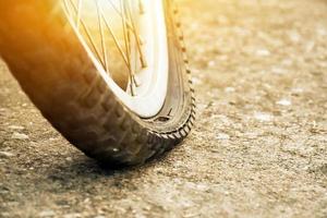 dichtbij omhoog visie van fiets welke heeft vlak band en geparkeerd Aan de stoep, wazig achtergrond. zacht en selectief focus Aan band. foto