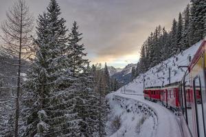 rood trein in de sneeuw in Zwitsers Alpen foto