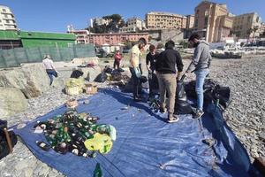 Genua, Italië - februari 28 2021 - jong vrijwilligers verzamelen plastic en uitschot Bij de strand foto