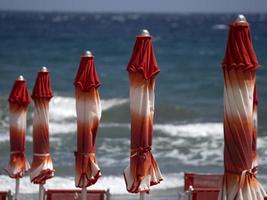 zomer zon paraplu's Aan Ligurië strand foto