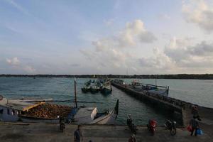 traditionele haven in de ochtend met verschillende vissersboten langszij en mensenactiviteiten op het eiland Masalembu, Indonesië. januari 2020, masalembu - Indonesië foto