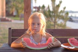 grappig meisje eet watermeloenplakken foto