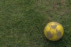 close-up van oude voetbal die op gras ligt. foto