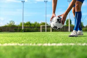 professionele voetbal of voetballer schopt en schiet de bal naar een penalty of een vrije trap naar de keeper voor het winnen van het kampioensdoel in de laatste wedstrijdcompetitie in het veldstadion foto