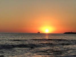 zonsondergang zee met boot foto