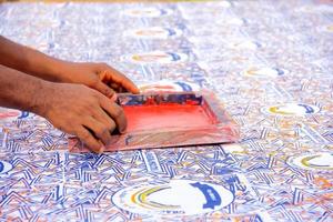 overhandig een kunstenaar die een rakel op een zeefdrukdoos drukt om op doek te drukken. foto