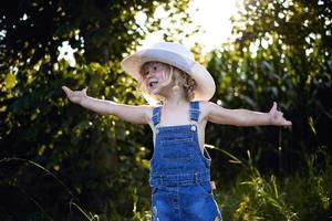 klein blond meisje dat op het platteland speelt foto