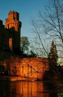 oud europees middeleeuws architectonisch gebouw kasteel in gouden herfstlicht met de blauwe hemelachtergrond in de herfst foto