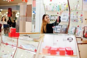 portret van jonge blanke vrouwelijke vrouw verkoper. klein bedrijf van snoep souvenirs winkel. foto