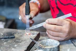 handen werken Aan zilver ring dichtbij omhoog detail foto