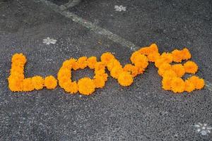 liefde woord gemaakt door oranje bloem detail foto