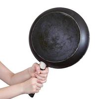 zwart koekepan in vrouw handen geïsoleerd foto