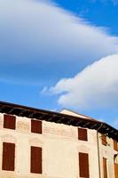 wit wolken in blauw lucht onder middeleeuws huis foto