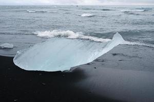 blokken van glaciaal ijs gewassen aan wal Bij diamant strand, IJsland foto