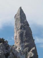 klimmer Aan goloritze rots klif door de zee Sardinië Italië foto