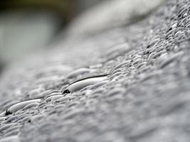 regen druppels Aan blauw metaal dichtbij omhoog macro foto