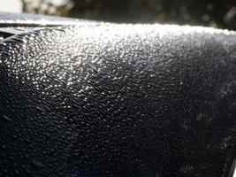 dauw water druppels Aan blauw metalen oppervlakte foto