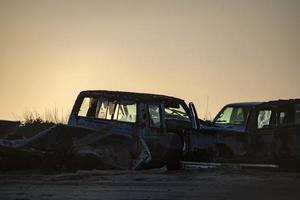 in de steek gelaten auto's silhouet Bij zonsondergang foto