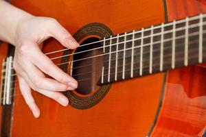 vrouwelijke hand akoestische gitaar spelen foto